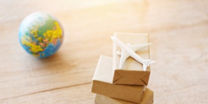 Avión de plástico sobre cajas de cartón y un globo terraqueo