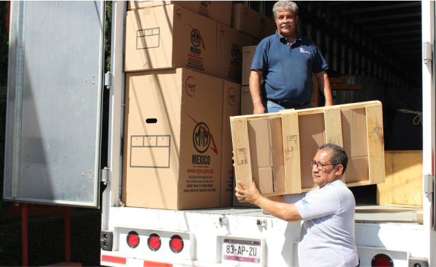 Operadores de MyM by Traxión cargando cajas de mudanza en un camión