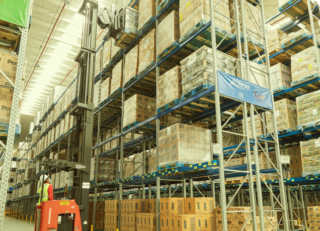 Bodega con estanteria en gran volumen almacenando mercancia en cajas de carton 