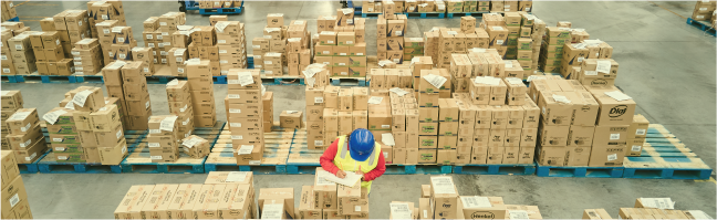 Bodega con almacenamiento de mercancias en cajas de carton, acompañada de operarios